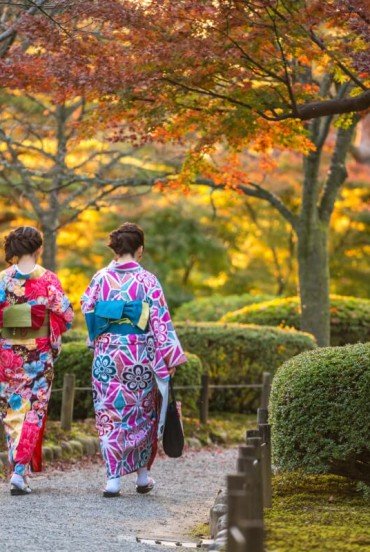 Girls in traditional clothing strolling through the paths of Kenroku-en Park in Kanazawa, Ishikawa Prefecture, considered one of Japan’s three most beautiful gardens.